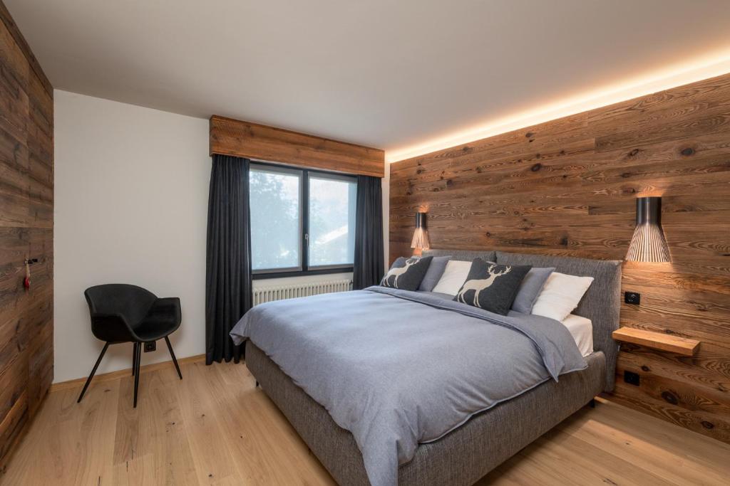 クランにあるL'appartement de Marieのベッドと木の壁がある寝室