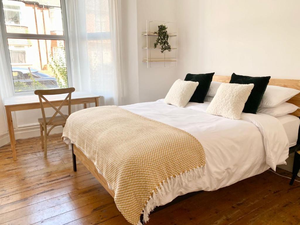 - une chambre dotée d'un grand lit avec des draps et des oreillers blancs dans l'établissement 50 Biddlestone Road Heaton, à Newcastle upon Tyne