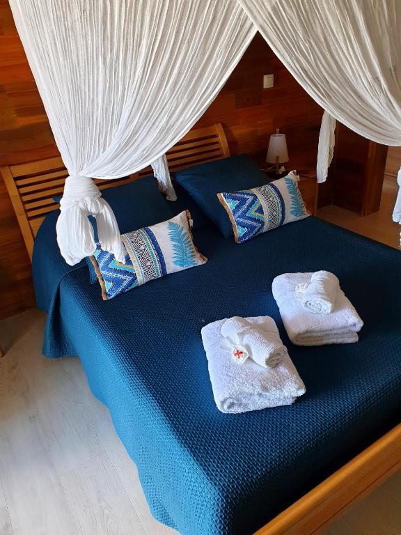 a bed with towels on it with a canopy at Gîte 4 étoiles, la Vieille Sucrerie St Claude Guadeloupe, Jacuzzi Spa privatif, vue exceptionnelle sur la mer des Caraïbes in Basse-Terre