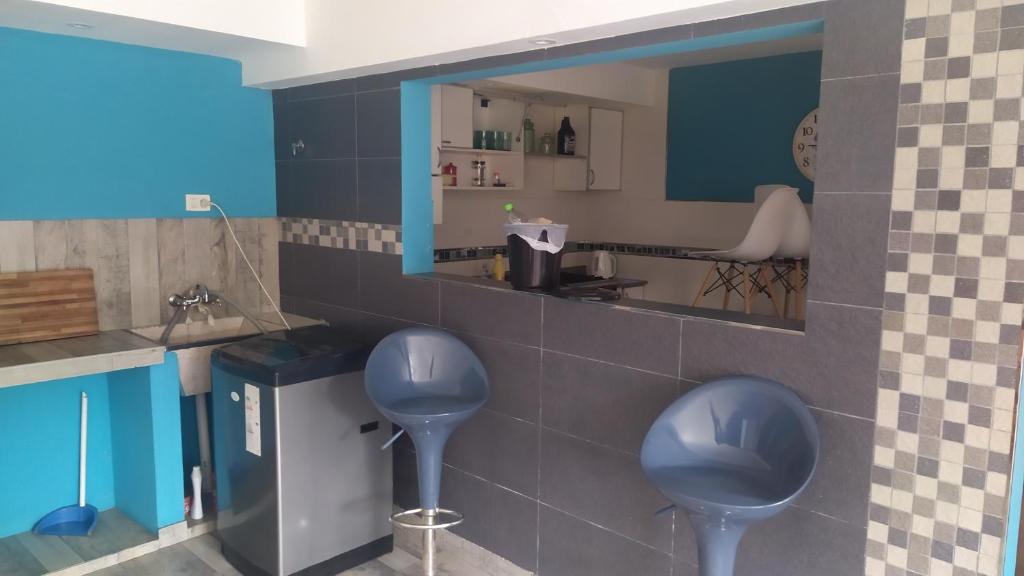 a bathroom with two blue stools and a mirror at Mar del Plata Sur 2 in Mar del Plata