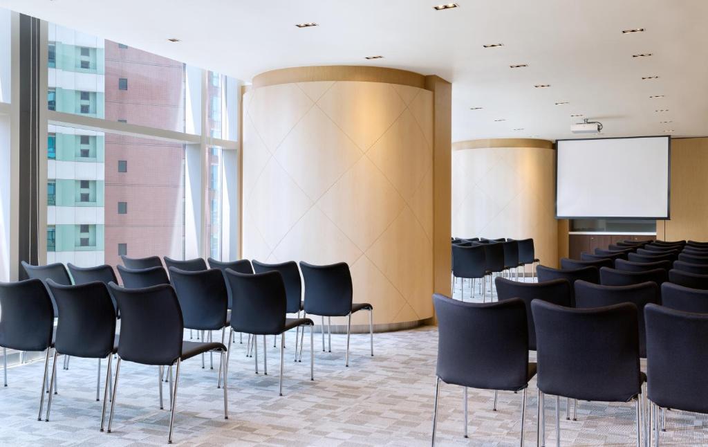 a conference room with black chairs and a whiteboard at Ibis Hong Kong Central & Sheung Wan in Hong Kong