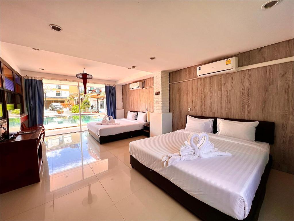 a bedroom with two beds with white towels on them at Baankasemsuk Resort 般咔 深宿 in Patong Beach