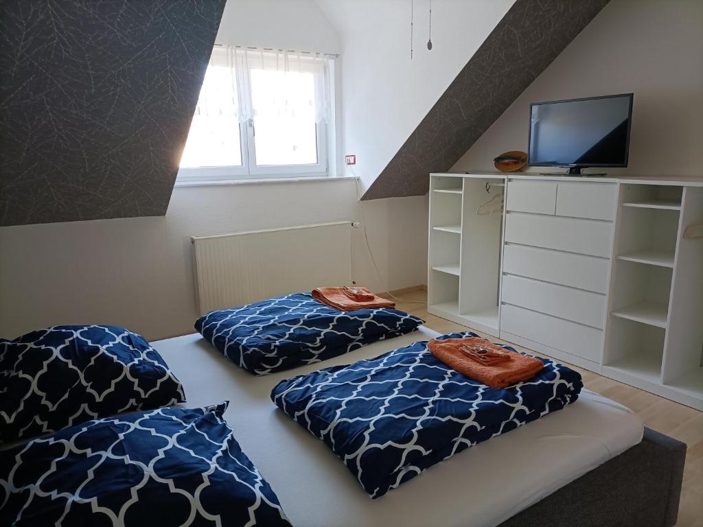 a room with two pillows on a bed with a tv at Schöne Wohnung mit Whirlpool und Sauna 