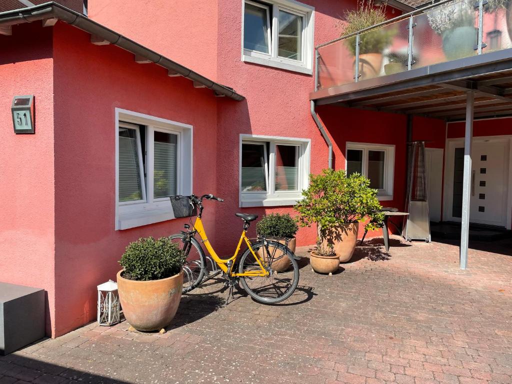 uma bicicleta amarela estacionada ao lado de um edifício vermelho em Studio em Wilhelmshaven