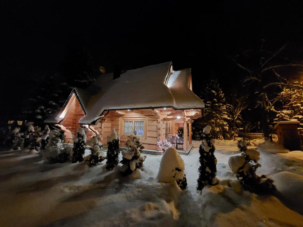 een huis versierd met kerstverlichting in de sneeuw bij BIAŁY PUCH in Zakopane
