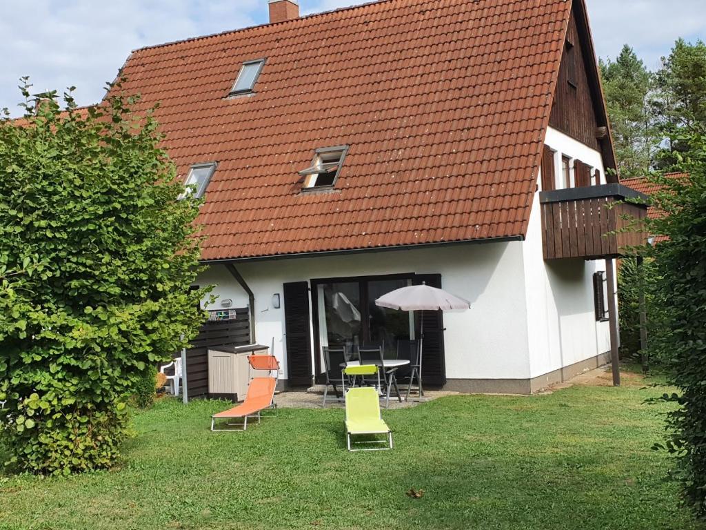una casa con mesa, sillas y sombrilla en Ferien­wohnung Baumann, en Pleinfeld