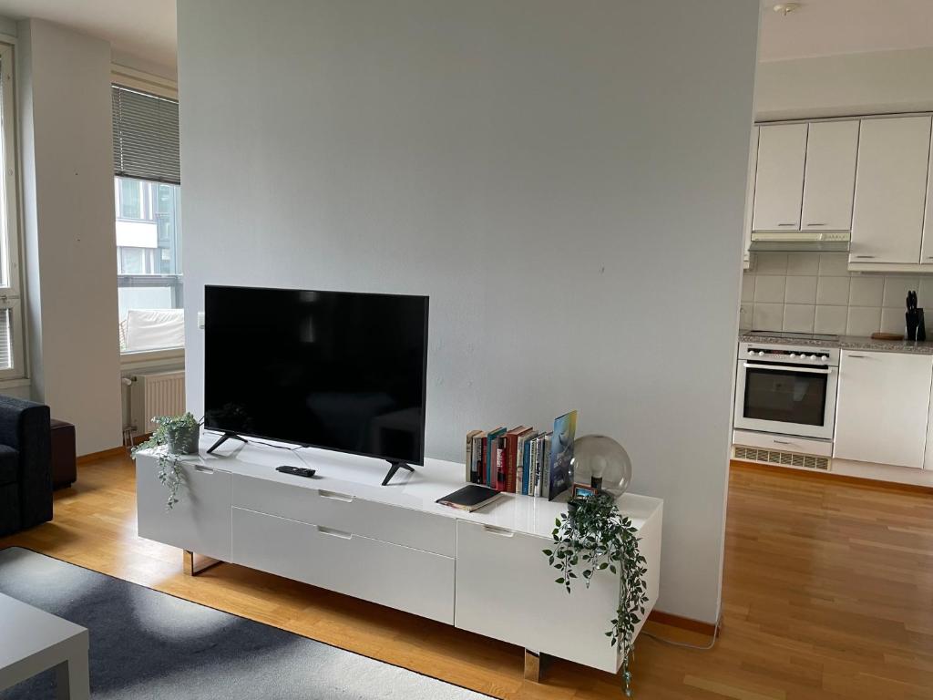 una sala de estar con TV de pantalla plana en un armario blanco en Sea, Sauna and City Center, en Helsinki