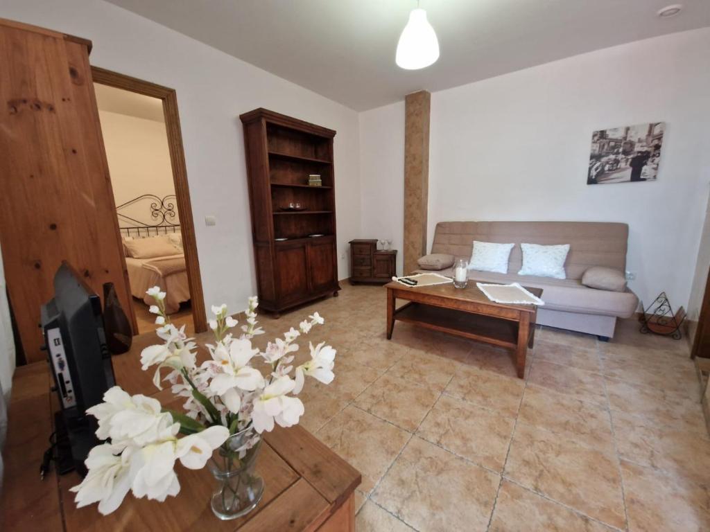 - un salon avec un canapé et une table fleurie dans l'établissement Apartamento Marbella, à Marbella