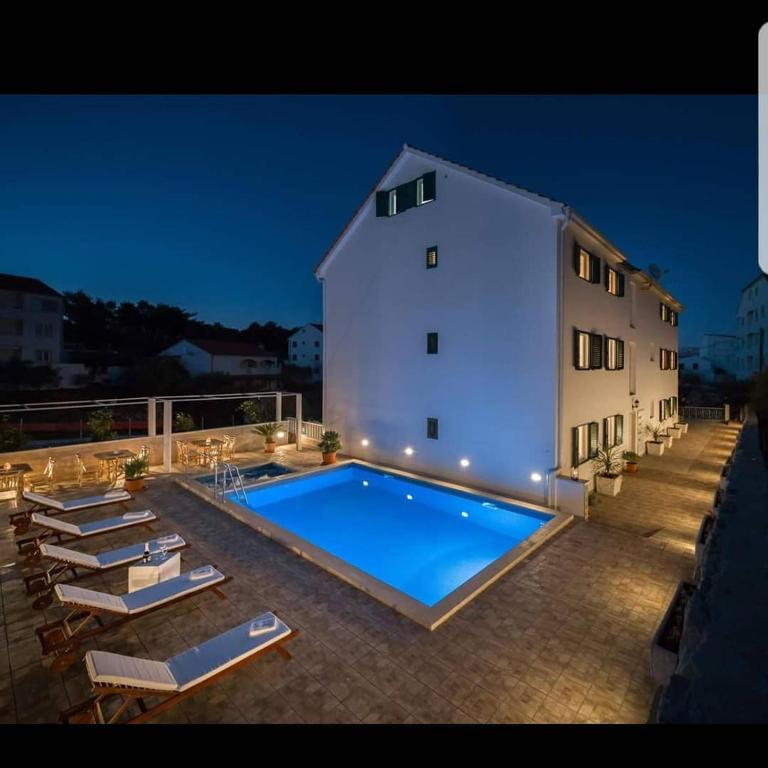 a building with a large swimming pool next to a building at La Perla Apartments in Sutivan
