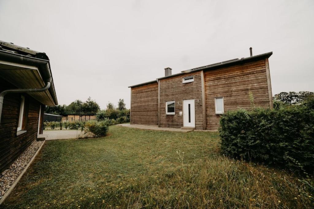 a small wooden building next to a grass yard at Haus Holli Zarrentin am Schaalsee in Zarrentin