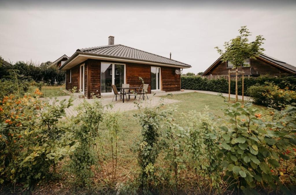 a log cabin with a table and chairs in a yard at Haus Hilde Zarrentin am Schaalsee in Zarrentin