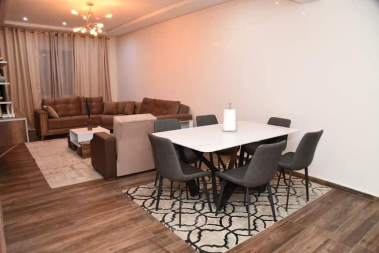uma sala de estar com uma mesa e cadeiras e um sofá em Haut-Standing- Appartement-Fes-City em Fez