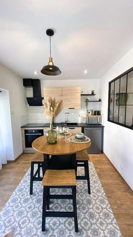 une cuisine avec une table avec un vase dessus dans l'établissement Appartement cosy & balnéo - Centre de Sarlat, à Sarlat-la-Canéda