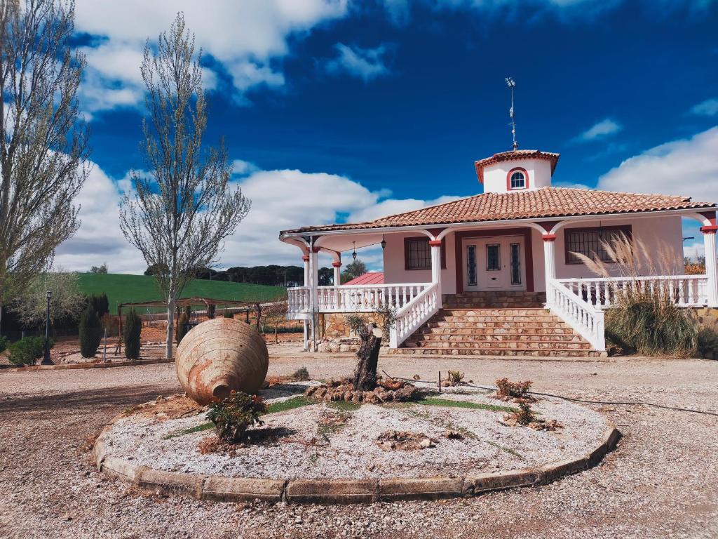 a small white house with a large barrel in front of it at Casa rural cascales 