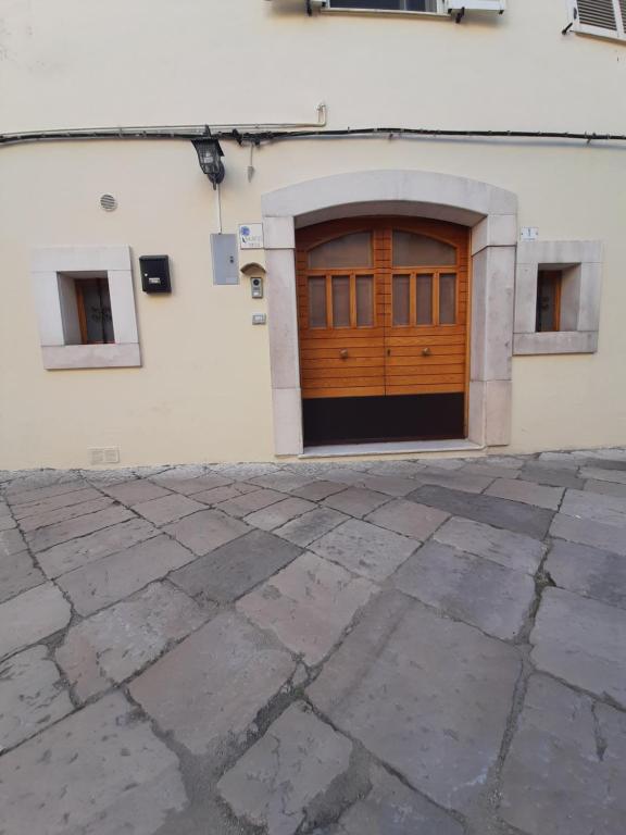 uma porta de garagem de madeira num edifício branco em Casa vacanza, Vacanties Domina em Fondi