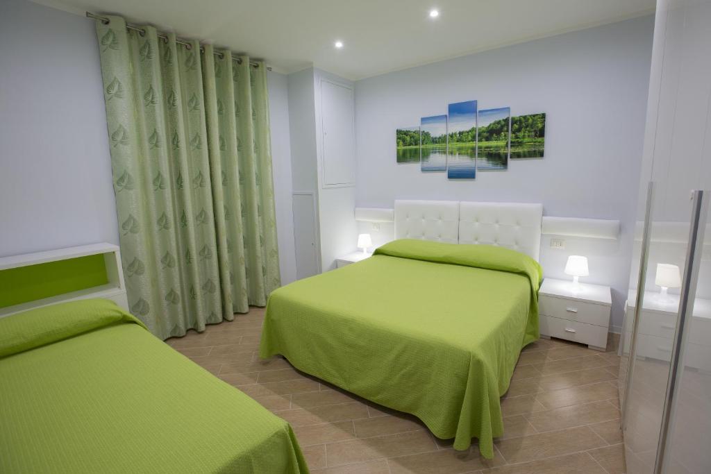 a bedroom with two beds with green sheets at Residenza Duomo in Avezzano