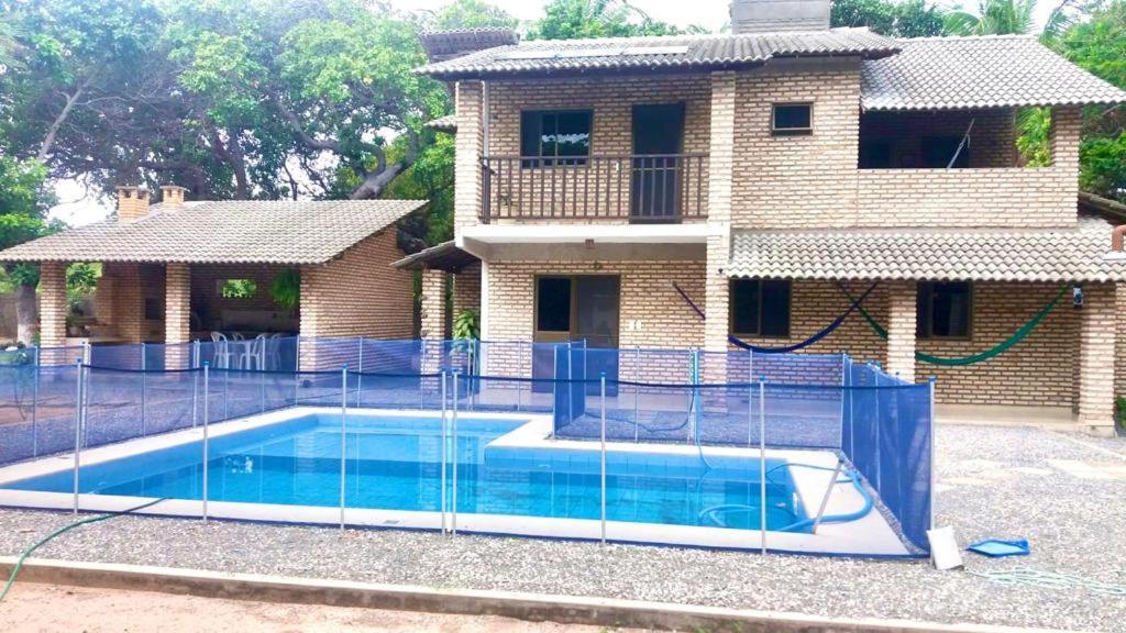 a house with a swimming pool with a fence around it at RECANTO da LAGOA in Jijoca de Jericoacoara
