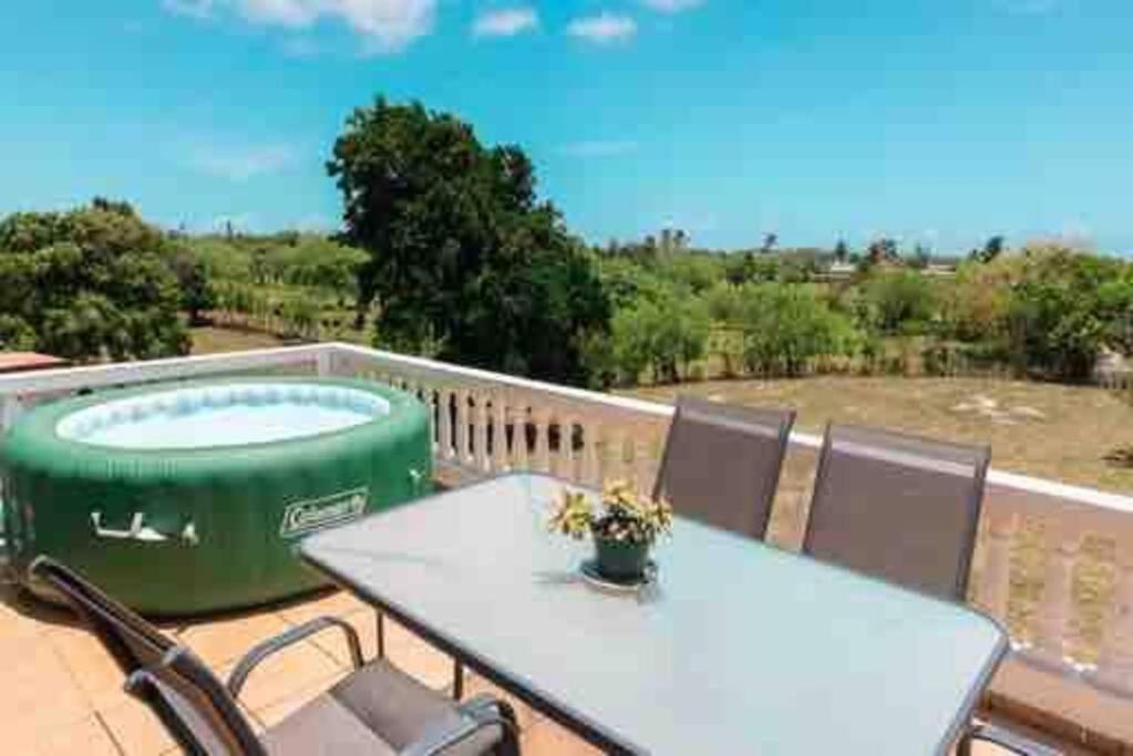 una mesa y sillas en una terraza con bañera de hidromasaje en Playa y Campo Getaway Apartment, with Hot Tub en Isabela