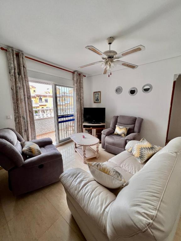 a living room with two couches and a ceiling fan at Calle canarias in Gran Alacant