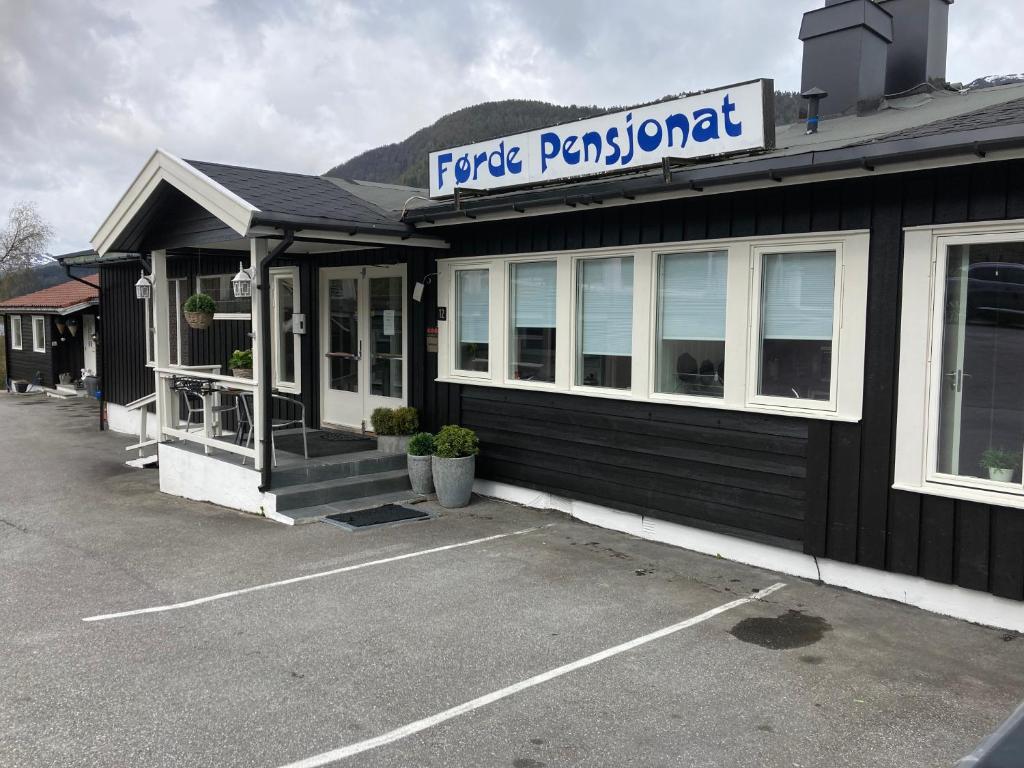um edifício preto com um cartaz que diz restaurante épico em Førde Pensjonat em Førde
