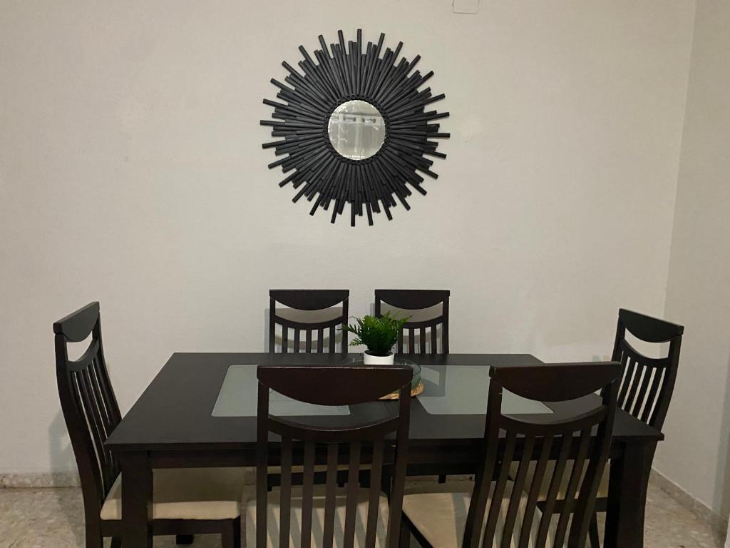 a dining room table with chairs and a mirror at Alhambra Apartments in Granada
