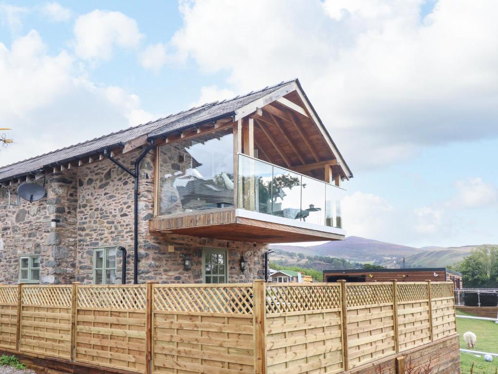 uma casa com uma varanda ao lado em Tyn Y Ceubren Bach at Evelyns Retreat em Corwen