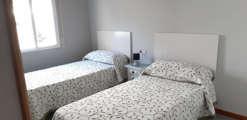 sypialnia z 2 łóżkami i lustrem w obiekcie Apartamento Alba w mieście Portonovo