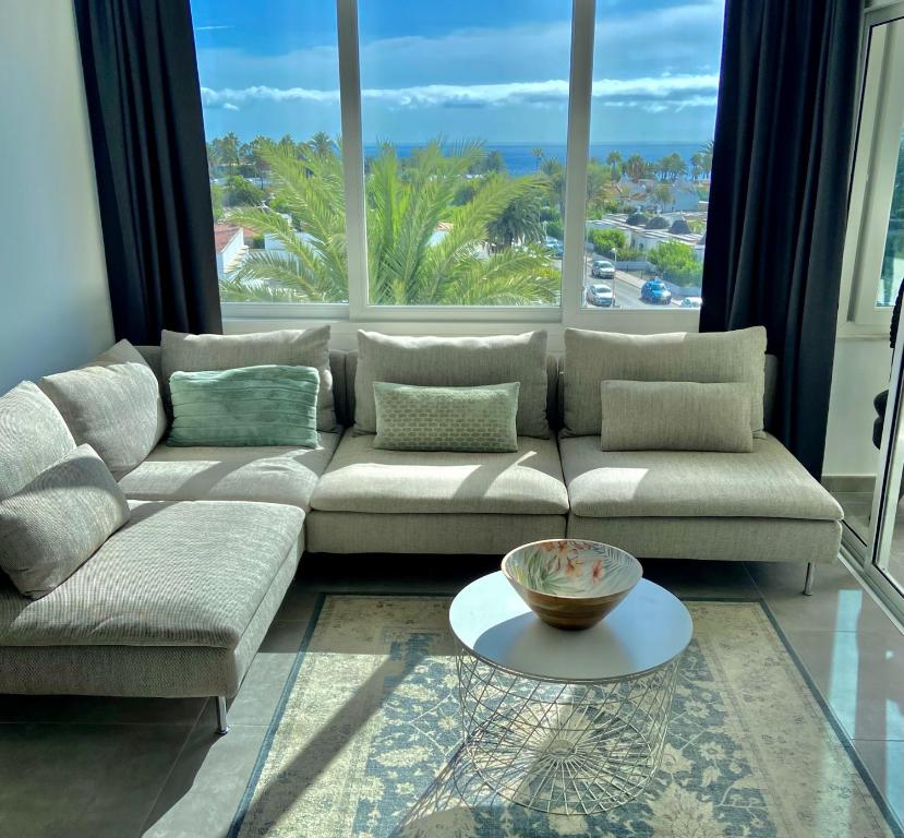 a living room with a couch and large windows at Excelsior I Sea View Apartment in Maspalomas