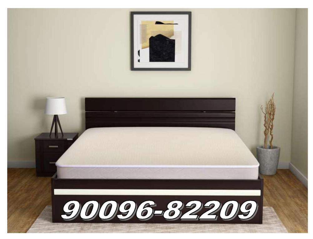 インドールにあるNarmada Guest Houseのベッドルーム1室(白黒のマットレス付きのベッド1台付)