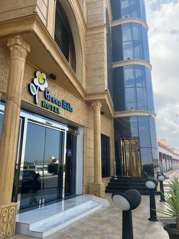 a building with a sign that reads green link house at فندق التلال الخضراء in An Nimāş