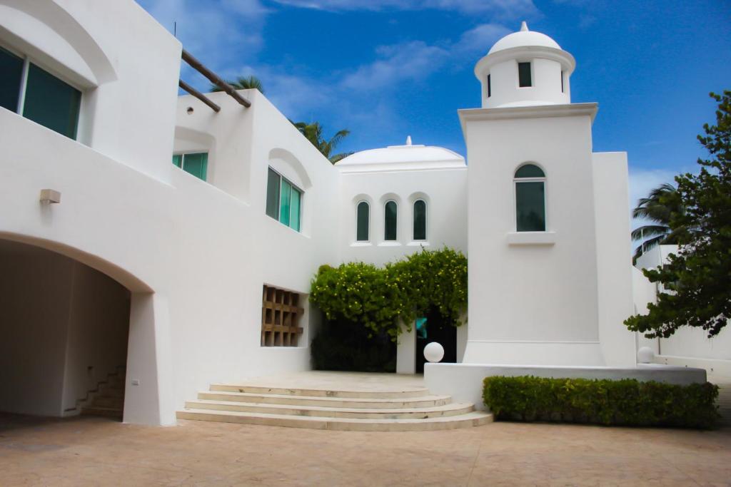 a white building with a clock tower at Villa Santorini in Uaymitun