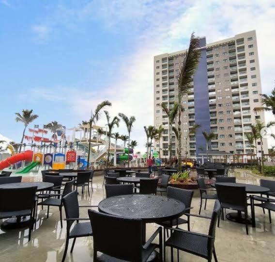a patio with tables and chairs and a building at Salinas Exclusive Resort in Salinópolis