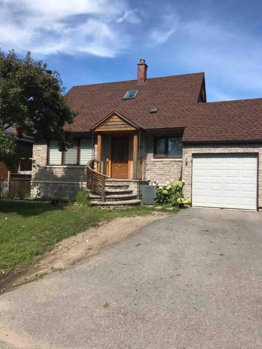 a house with a white garage door and a driveway at A Gem in the Heart of Ottawa in Ottawa