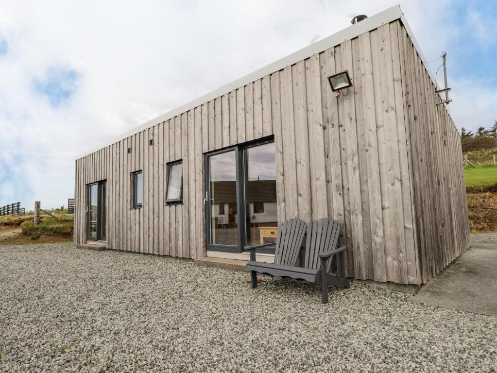 The Cabin في Lonmore: مبنى خشبي أمامه مقعد