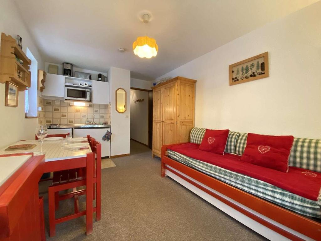 a living room with a red couch and a kitchen at Appartement Praz-sur-Arly, 2 pièces, 4 personnes - FR-1-603-60 in Praz-sur-Arly