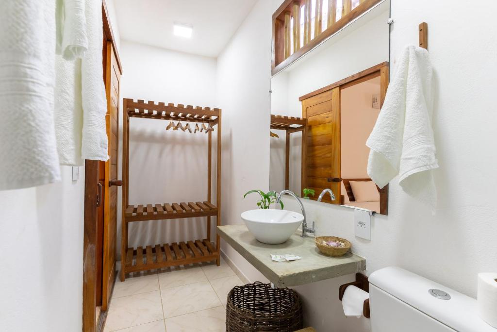 uma casa de banho com um lavatório e um espelho em Casa Luar Trancoso em Trancoso