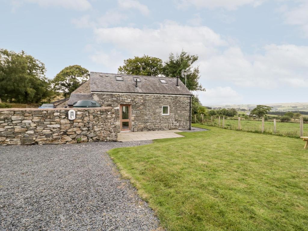 una imagen de una casa de campo de piedra con un gran patio en Bryn Dedwydd Cottage en Betws-y-coed