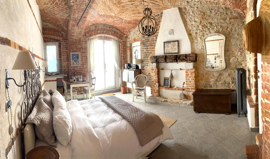 a bedroom with a bed and a brick wall at Cascina Viaris in Pavarolo