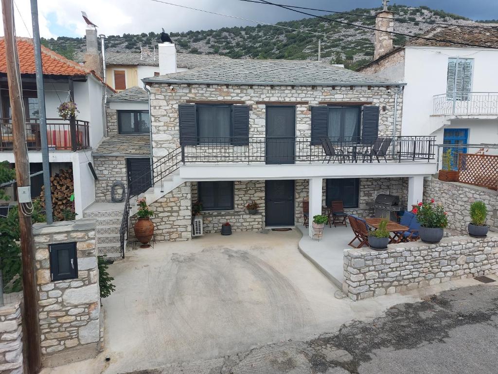 a stone house with a patio and a balcony at Maria Tsomou in Theologos