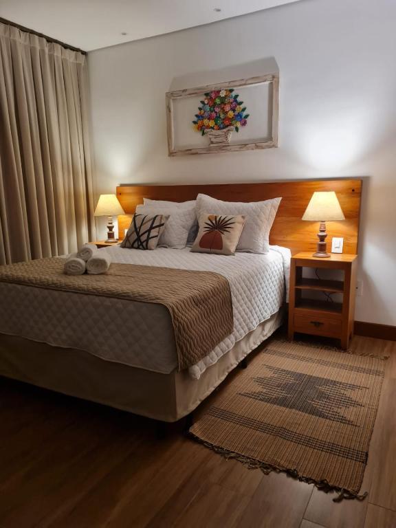um quarto com uma cama com 2 candeeiros e 2 mesas em Pousada Candelabro em Tiradentes