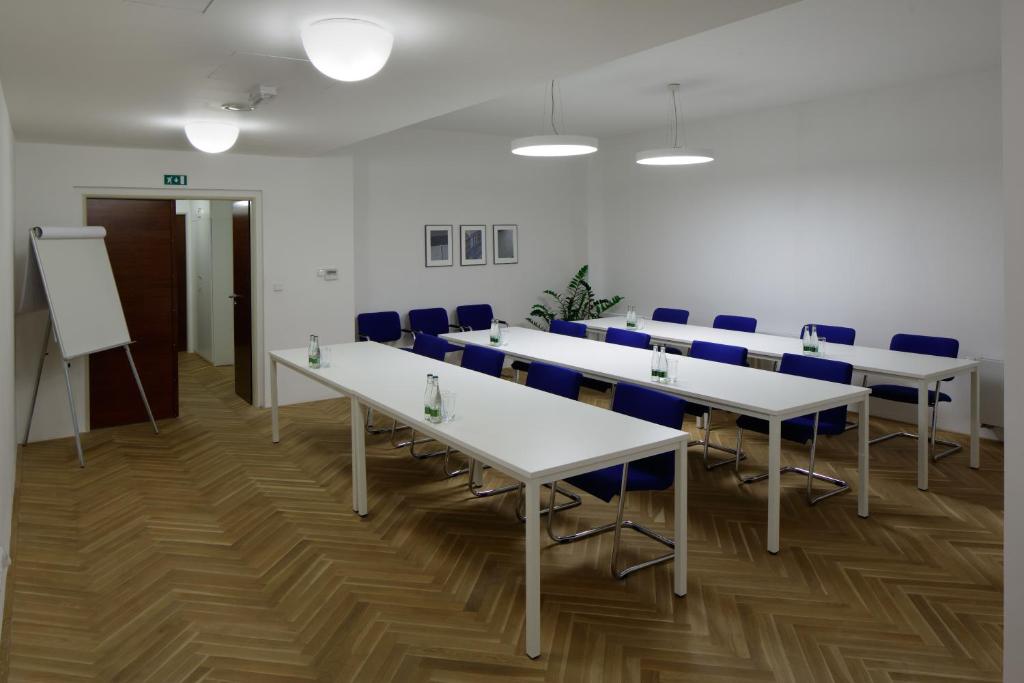 sala konferencyjna z białymi stołami i niebieskimi krzesłami w obiekcie AXA Hotel w Pradze