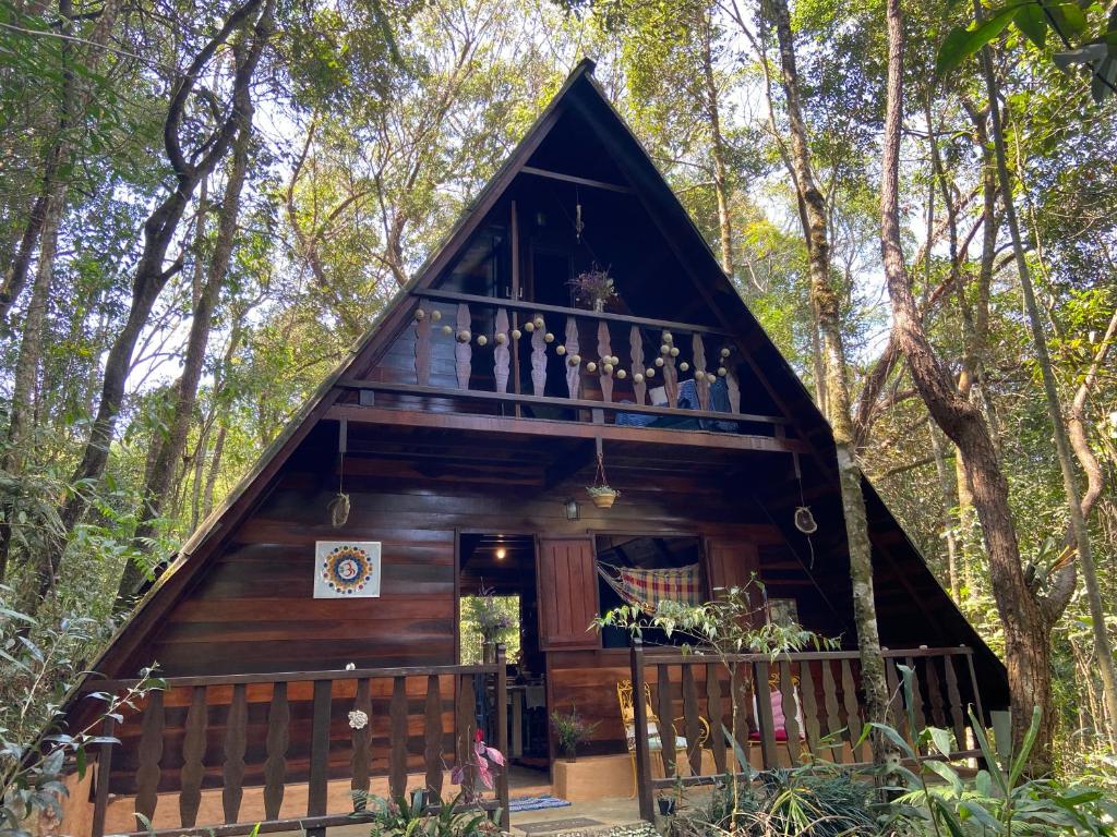 uma casa na árvore no bosque com uma varanda em Chalé Floresta Amada em Ouro Preto