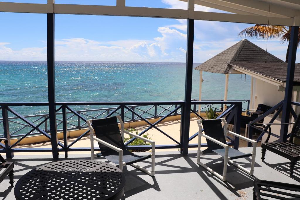 a balcony with chairs and a view of the ocean at Little Reef Villa in Saint James