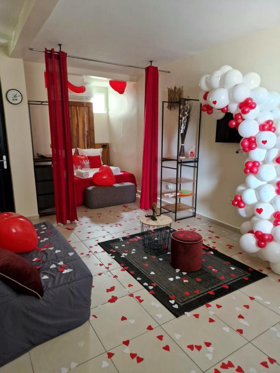a living room with red and white balloons on the floor at Studio jacuzzis et piscine au centre ville de Port-Louis in Port-Louis