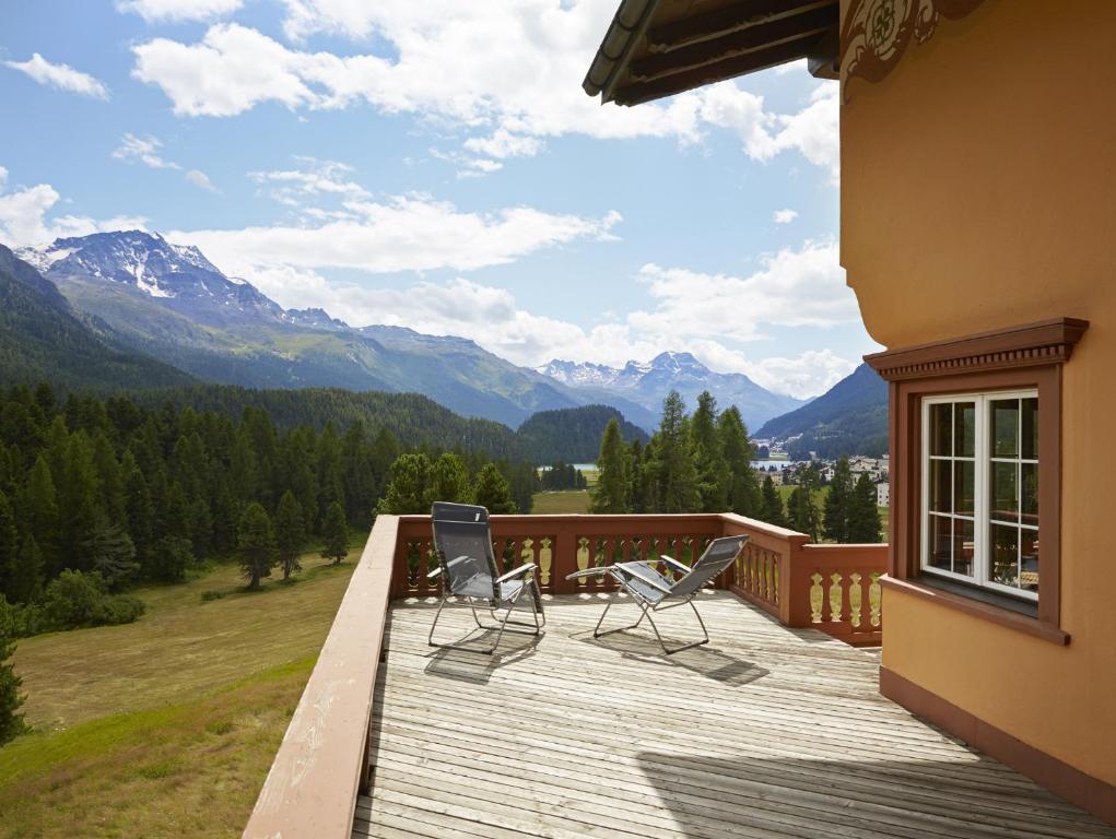 - deux chaises sur une terrasse avec vue sur les montagnes dans l'établissement Hotel Chesa Spuondas, à Saint-Moritz