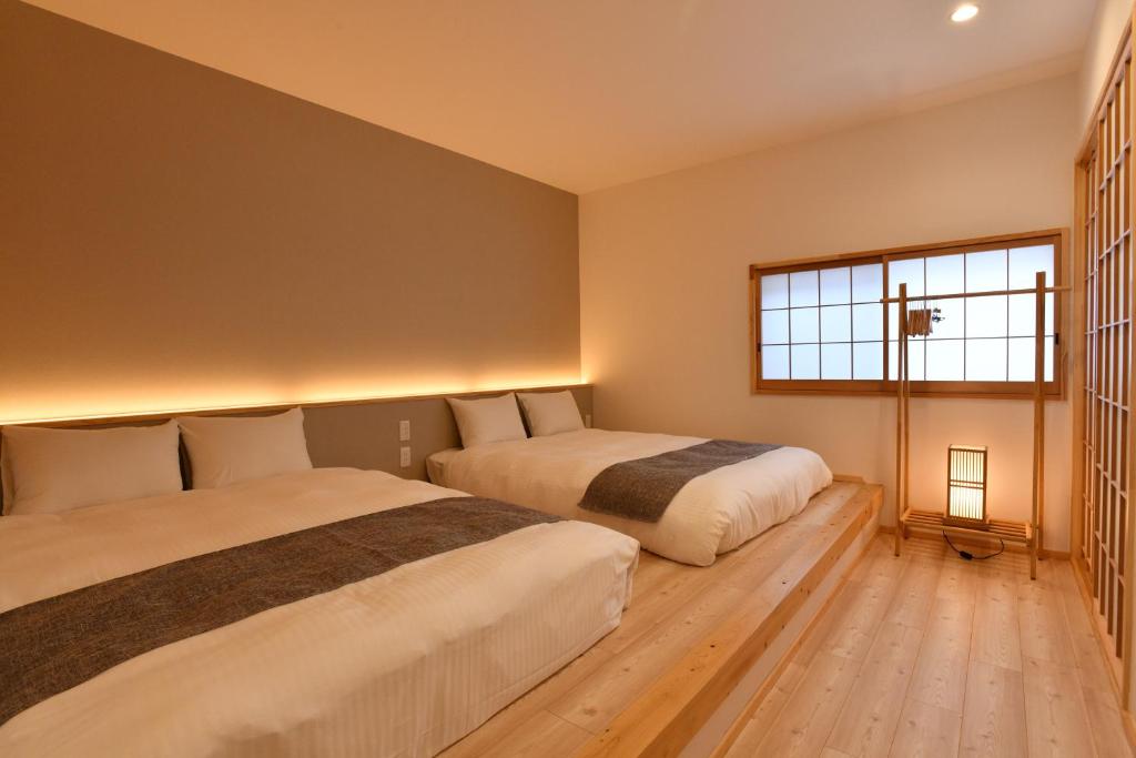 - une chambre avec 2 lits et une fenêtre dans l'établissement FL House 浪花町, à Osaka