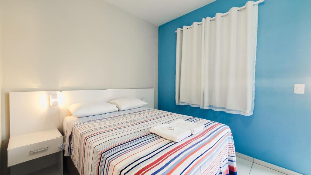 a bedroom with a bed with two towels on it at Pousada Paraiso de Arempebe in Arembepe