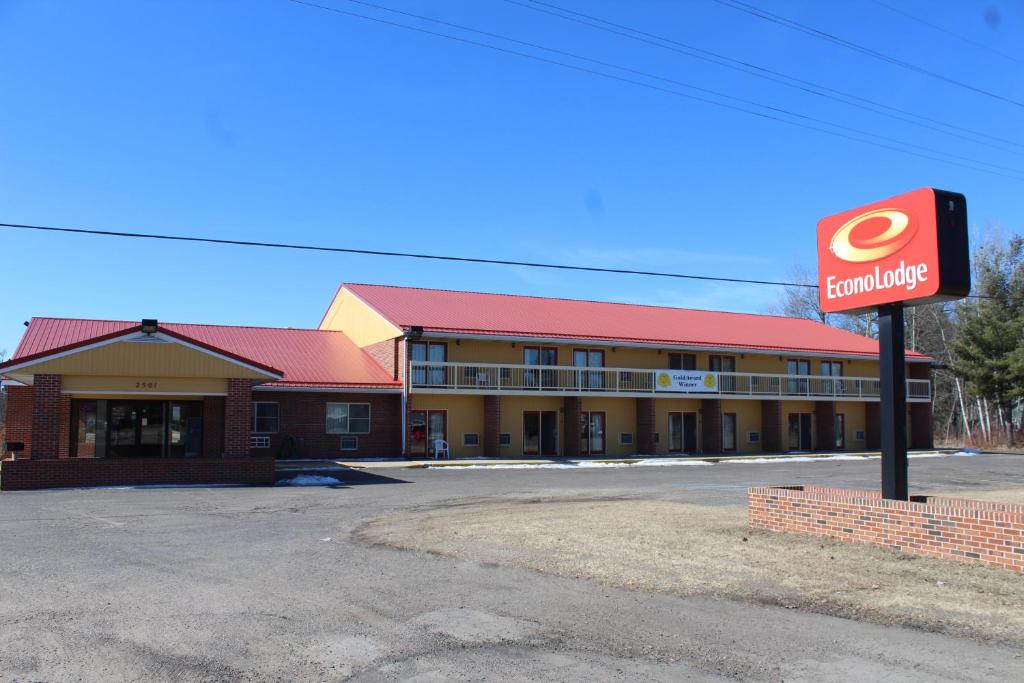 un edificio con una señal delante de él en Econo Lodge by Choicehotels, en Cadillac