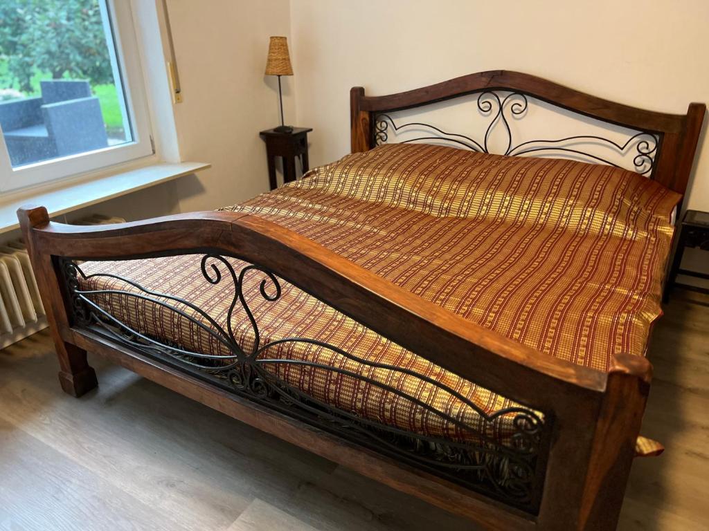 Schlafzimmer mit einem Bett mit einem Holzrahmen und einem Fenster in der Unterkunft Hummelglück - Ferienwohnung mit Terrasse in 30 Min in HH City in Bendestorf
