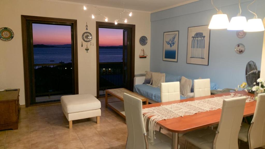 a dining room with a table and chairs and a couch at Yulia Guest House in Ouranoupoli